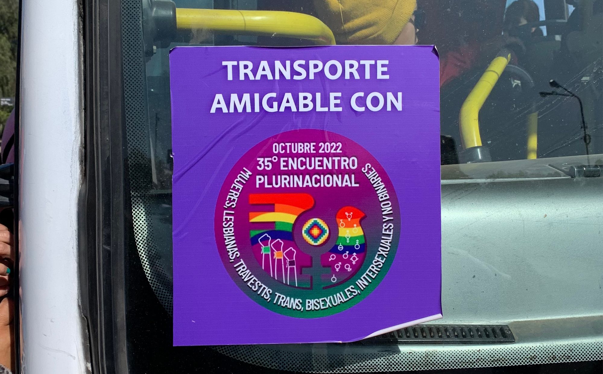 Sticker with the logo of the 35th Encuentro. The logo shows a rainbow-striped dove with symbols of the various genders and three raised fists. 